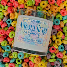 Load image into Gallery viewer, WSC Candle Co candle labeled &#39;Morning Cartoons&#39; on a bed of colorful cereal loops.
