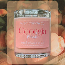 Load image into Gallery viewer, Pink candle labeled &#39;Georgia peach&#39; by WSC Candle Co with peaches in the background
