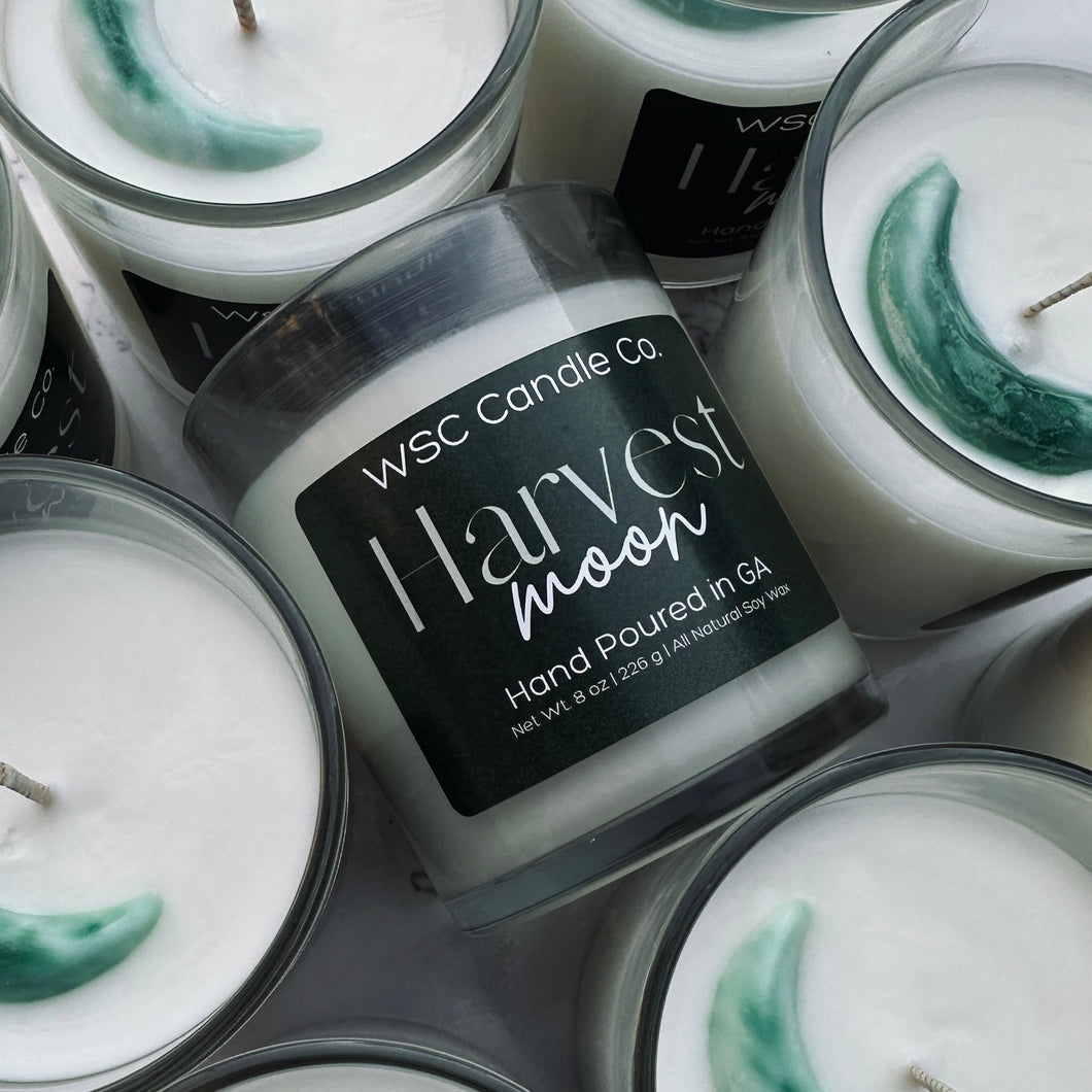 WSC Candle Co Harvest Moon candles with a jar labeled 'Harvest Moon' on a gray surface.